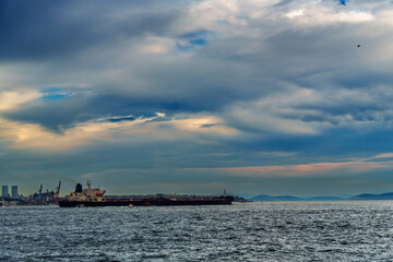 Obraz premium A large tanker ship sails along the Bosphorus against the background of Istanbul, Turkey, a view from a pleasure boat