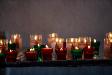 Ensemble de bougies allumées dans la nuit. Fond de bougies abstrait. Lumière dorée de la flamme de la bougie.
