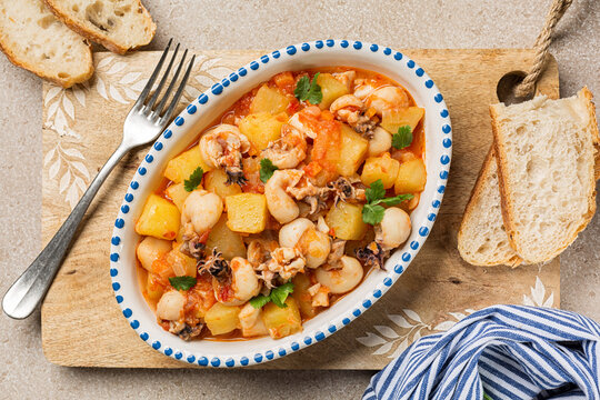 Top view of Cuttlefish stew with potatoes. Bread.
