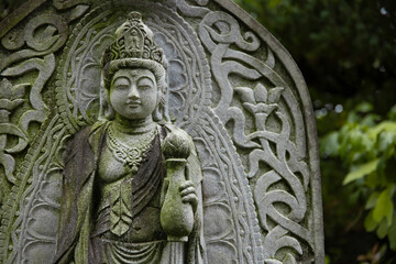 A religious stone statue of Kannon at Japanese buddhism temple
