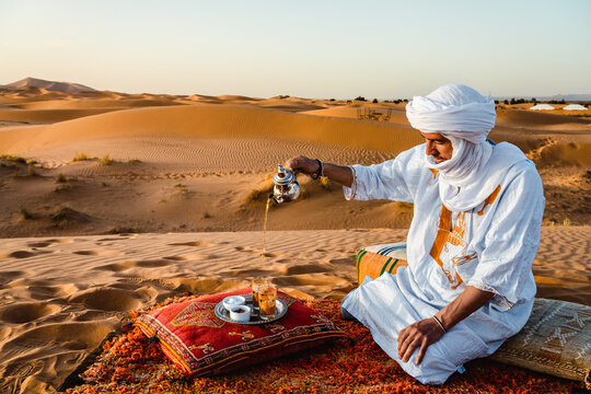 Berber man serving tea on a sand dune in the Sahara desert, Morocco