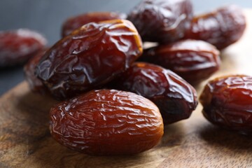 Tasty dried dates on wooden board, closeup