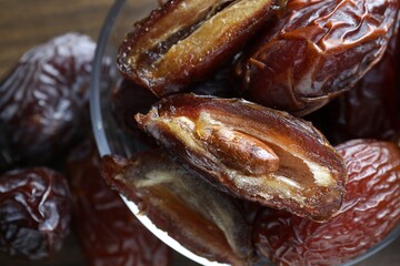 Many tasty dried dates in bowl on table, closeup