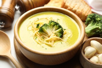 Delicious broccoli cream soup served on table, closeup
