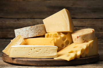 Different types of cheese on wooden table