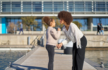 Fototapeta premium Mother and daughter sharing a tender moment on a pier