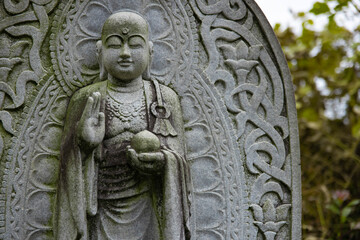 A religious stone statue of Jizo at Japanese buddhism temple