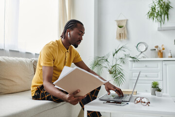 Young African American man working remotely in a bright modern space with greenery