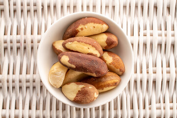 Brazil nut with homemade kitchen utensils, macro, isolated on white background and top view.
