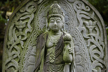 A religious stone statue of Kannon at Japanese buddhism temple
