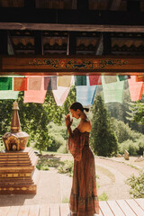 Woman practicing yoga and meditation in a Buddhist temple, relaxed with closed eyes. Mindful...