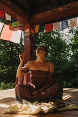 Woman practicing yoga and meditation in a Buddhist temple, relaxed with closed eyes. Mindful...