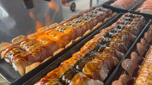 Flaming sushi and meat street food. Watch as we torch fresh sushi and meat over an open flame for an unforgettable culinary experience