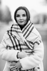 Portrait of a young beautiful dark-haired girl outdoors. Black and white photo.