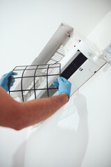Man cleaning  filters and maintaining air condition unit at home