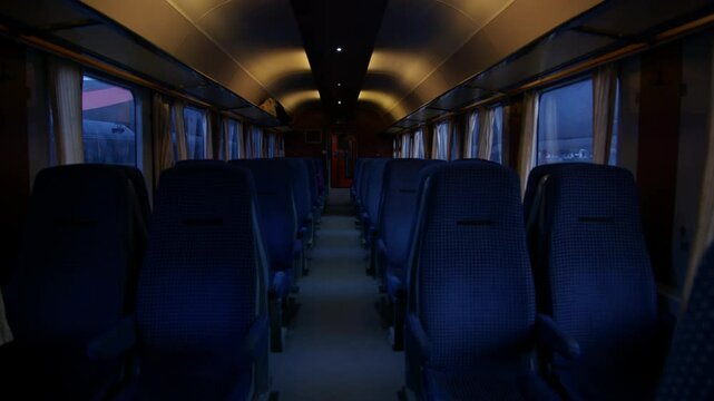 Interior view of train with blue upholstered seats.. Train with empty seats or bench. Inside view. Train standing still in the station and waiting for passengers to board. Passenger train. Romania.
