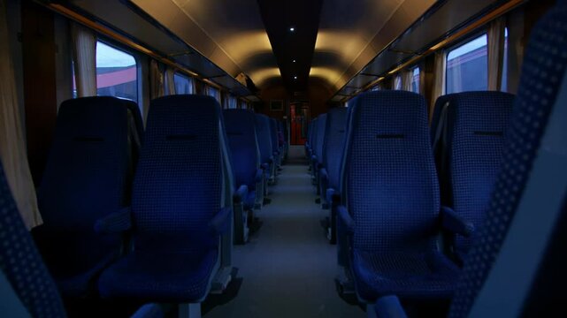 Interior view of train with blue upholstered seats.. Train with empty seats or bench. Inside view. Train standing still in the station and waiting for passengers to board. Passenger train. Romania.
