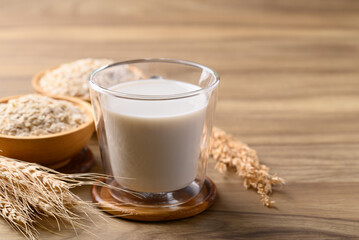 Oat milk in cup glass on wooden background, Alternative milk made from plant, non dairy