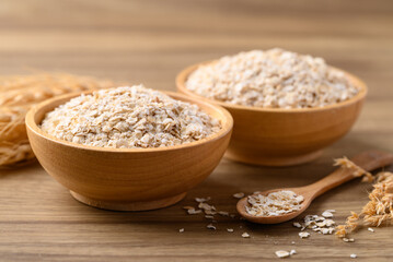Instant oat flakes in wooden bowl, Food ingredient in oatmeal, muesli or porridge