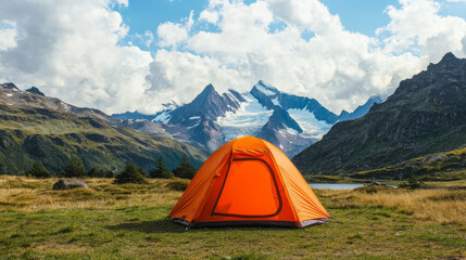 vibrant orange tent set against majestic mountains and serene lake