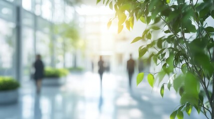 Blurred background of people walking in a modern office building with green trees and sunlight , eco friendly and ecological responsible business concept