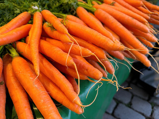 Bunch of bright orange carrots vegetables at a market stall