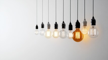 Various light bulbs suspend from ceiling, with one bulb illuminated among dark ones