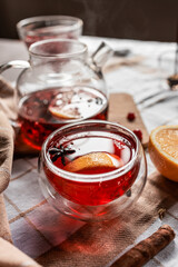red tea into a glass cup, hibiscus, tea with red berries, vitamin drink, winter tea for colds, lemon, red currant, black currant, raspberry, honey, cinnamon, anise