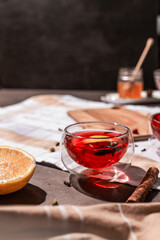red tea into a glass cup, hibiscus, tea with red berries, vitamin drink, winter tea for colds, lemon, red currant, black currant, raspberry, honey, cinnamon, anise