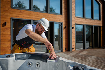 Plumber installing hot tub. Spa technician performing hot tub. Bathtub plumbing. Plumber fixing spa...