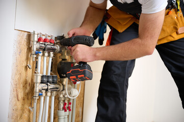 Man adjusting the heating system in a new apartment. Plumber adjusting heat on the central system...