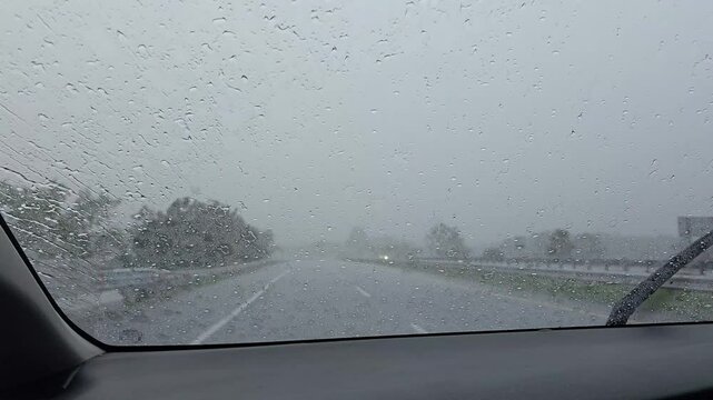 driving on a rainy day, the wiper cleans the rainwater from the car windshield