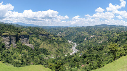 Fototapeta premium Lush valley with river, mountains, and clouds. Scenic view. Possible use Nature background.