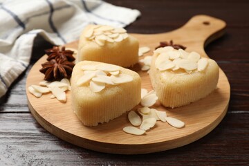 Pieces of delicious sweet semolina halva with almond flakes on wooden table, closeup