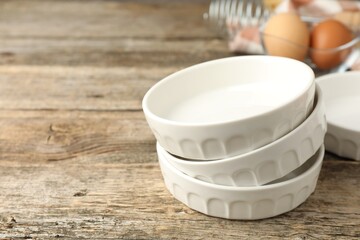 Ceramic casseroles on wooden table, closeup. Space for text
