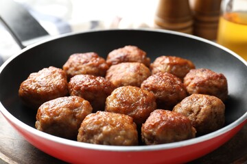 Tasty meatballs in frying pan on table, closeup