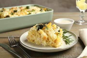 Tasty pasta casserole with cheese and broccoli served on wooden table, closeup
