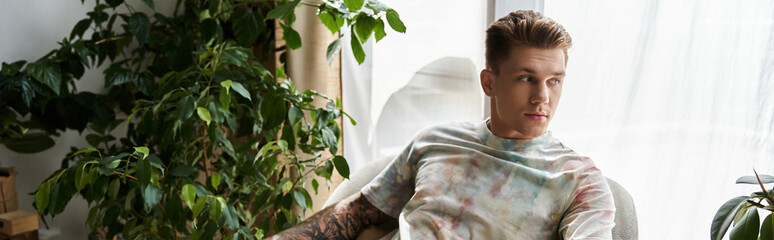 Handsome young man relaxing indoors with a prosthetic leg surrounded by lush greenery