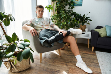 Handsome young man sitting comfortably in a stylish living room with a prosthetic leg