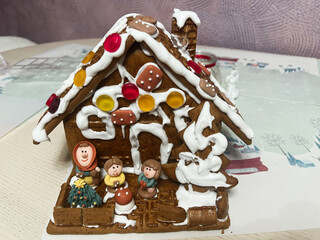 Candy Decorated Gingerbread House with Holiday Figurines on Display