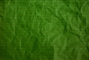 A sheet of wrinkled green glossy paper texture as background
