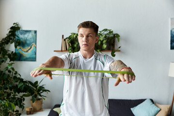 Young man with a prosthetic leg practicing fitness at home with resistance bands