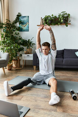 Achieving fitness goals at home young man stretches with prosthetic leg