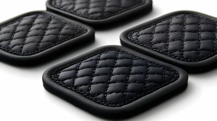 Four Black Quilted Leather Coasters Sit on a White Background with Stitched Edges and Soft Backing.