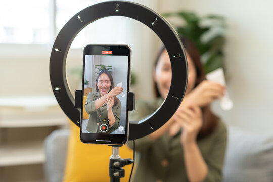 Influencer live internet, happy vlog asian young woman blogger using smart phone talking on video streaming podcast review online on social media, digital marketing with mobile content creator concept