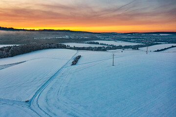 Bird's eye view of a snow-covered landscape at sunset near Idstein