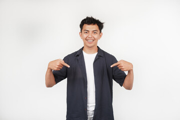 Smile and happy face a young of Asian man in grey shirt with hand pointing on empty space isolated on white
