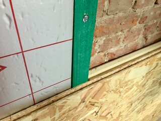 Close-Up of Wall Insulation with Brick and OSB Paneling