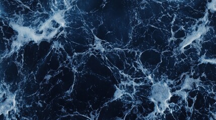 Abstract ocean wave texture, deep blue water with white foam.