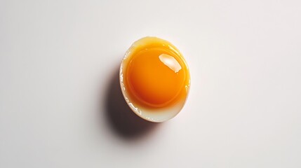 Boiled egg, cut in half to display the vibrant yolk, on a white background